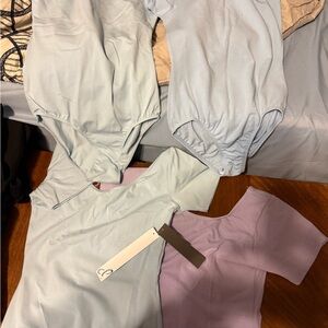 3 Light Blue and 1 Lavender body suits.  Blue women’s S, lavender girls xl.